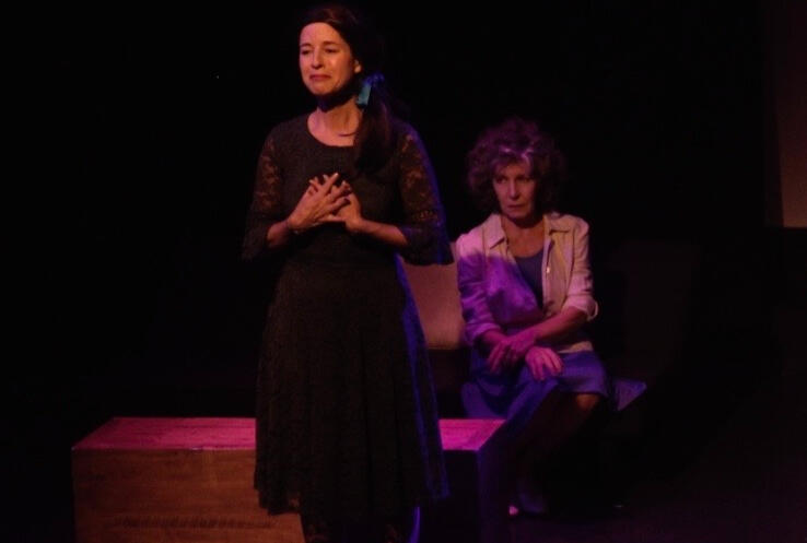 a theatrical scene showing two women